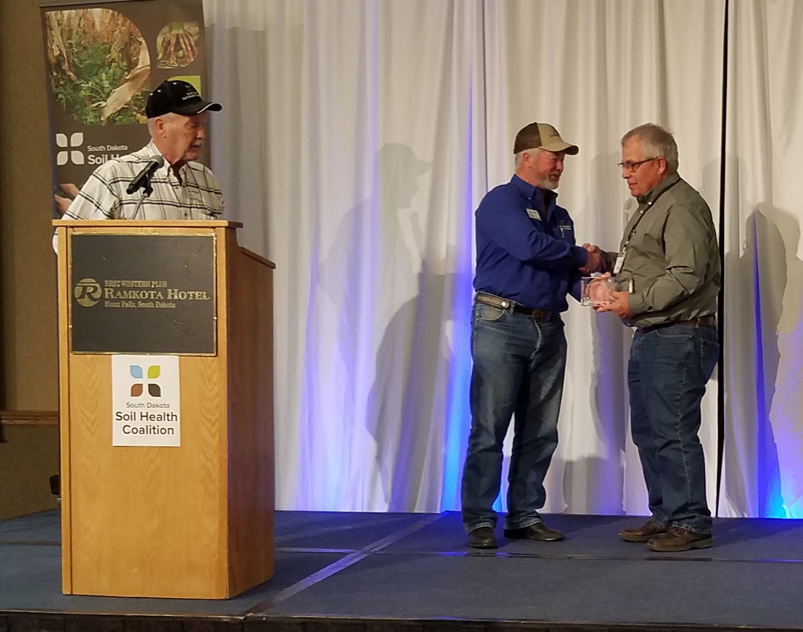 Dan Forgey, right, receives the 2023 Friend of Soil Health Award from SDSHC Board Member Doug Sieck, center, while SDSHC Board member Dennis Hoyle, left, looks on at the 2023 Soil Health Conference, Jan. 24-25 in Sioux Falls.